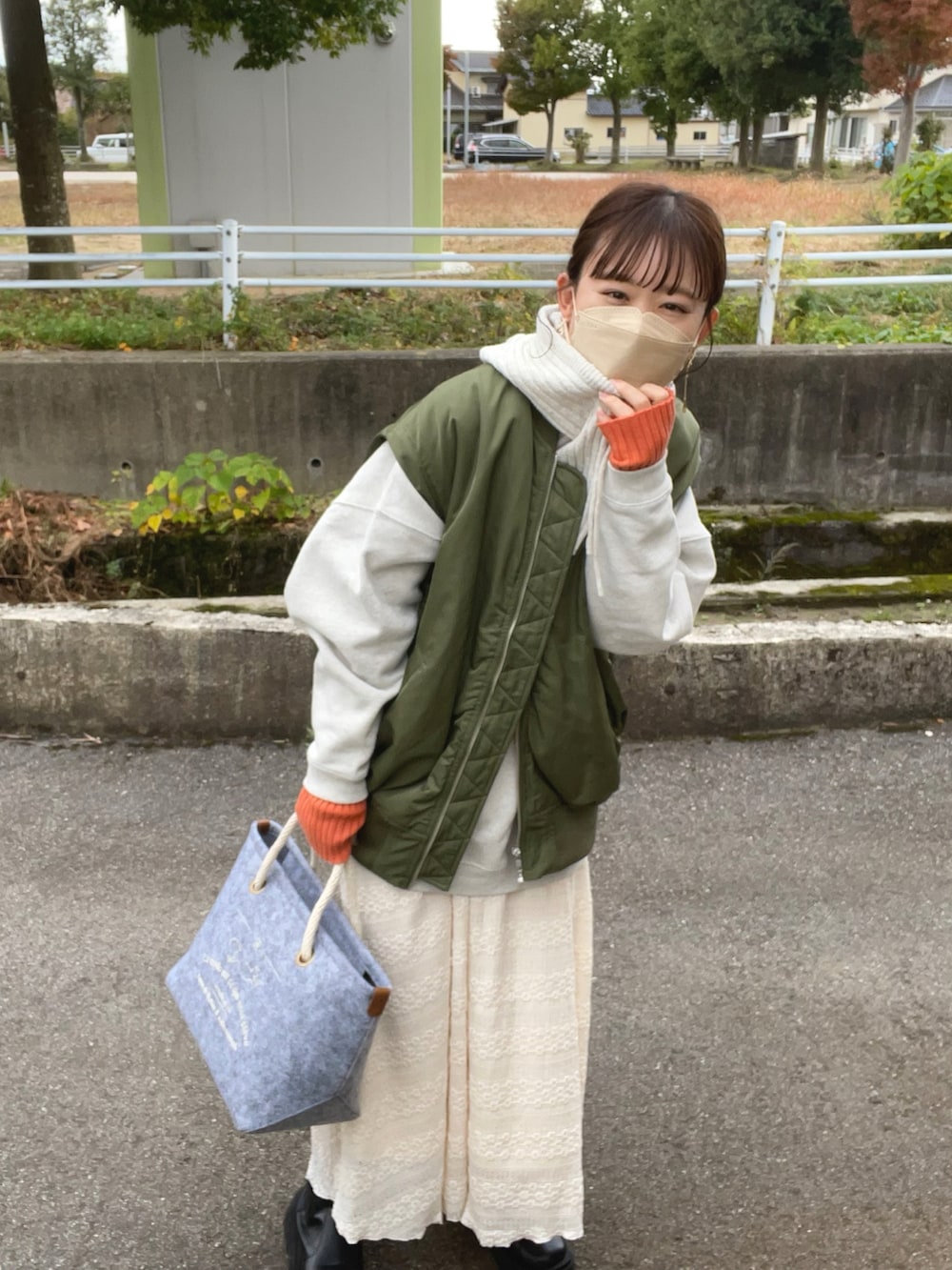 グレー系のトートバッグ、グレー系のスウェット、グリーン系のMA-1を着用したレディースの秋コーディネートの2枚目の写真