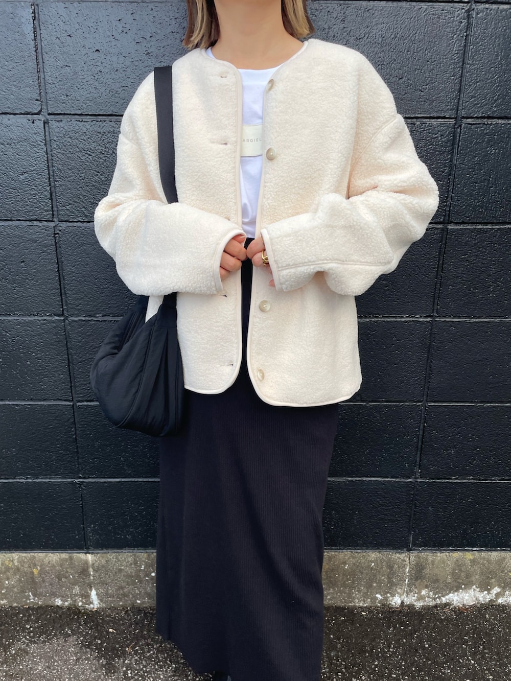 ホワイト系のジャケット/アウター、ホワイト系のTシャツ/カットソー、ブラック系のショルダーバッグを着用したレディースの秋コーディネートの3枚目の写真