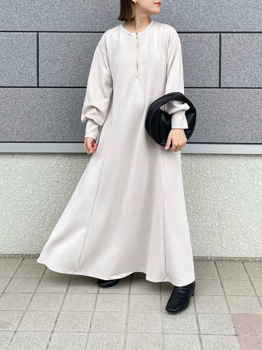 ホワイト系のワンピース、ベージュ系のその他アウター、ブラック系のハンドバッグを着用したレディースの秋コーディネートの5枚目の写真