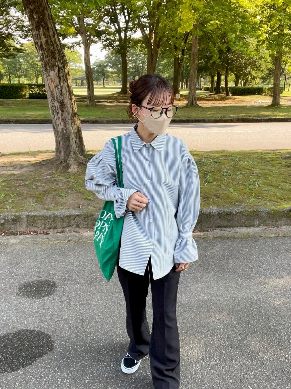 ブラック系のシャツ/ブラウス、ホワイト系のベスト、グリーン系のトートバッグを着用したレディースの秋コーディネートの3枚目の写真