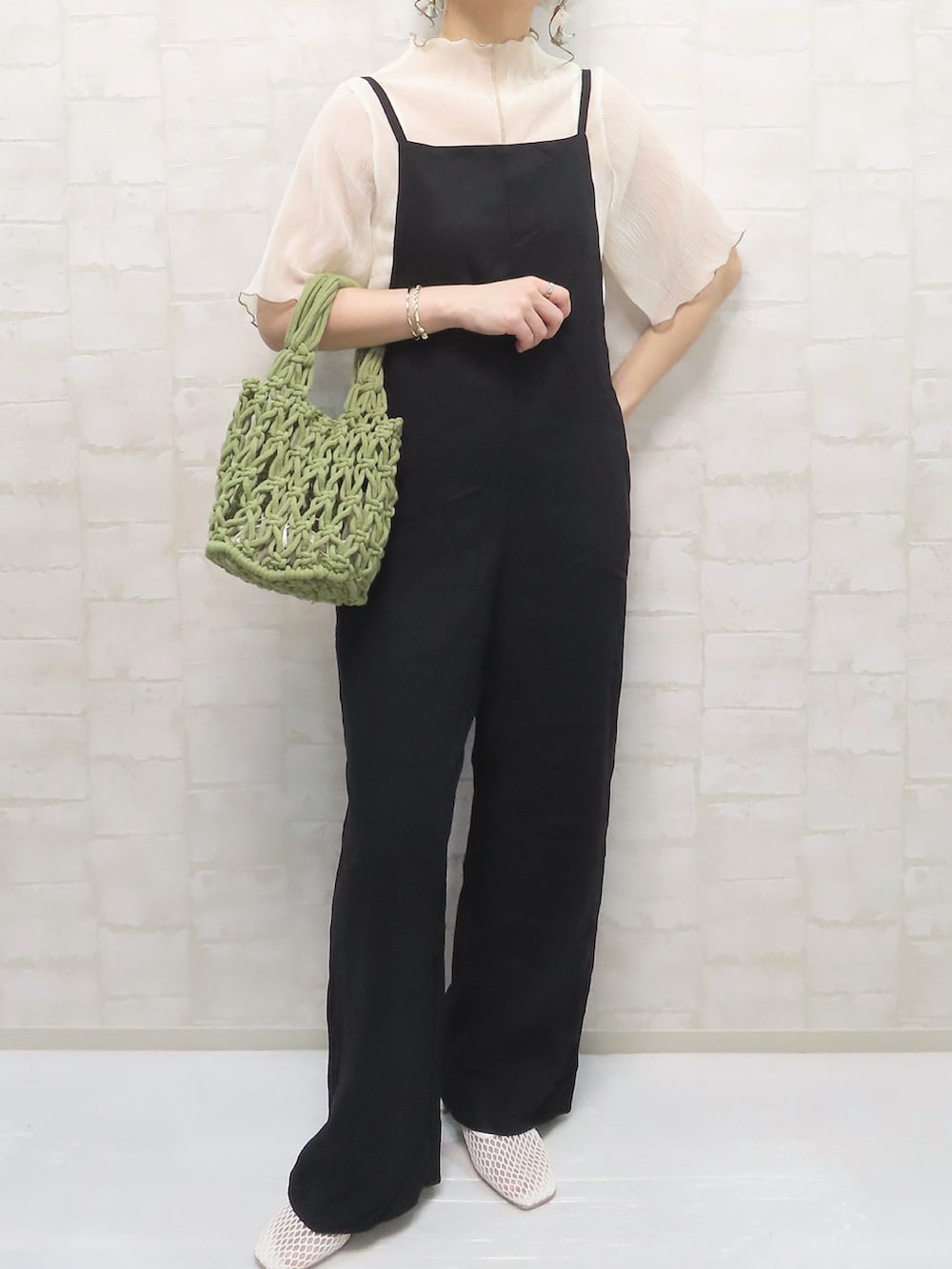 ホワイト系のTシャツ/カットソー、ブラック系のサロペット/オーバーオール、グリーン系のハンドバッグを着用したレディースの春コーディネートの4枚目の写真