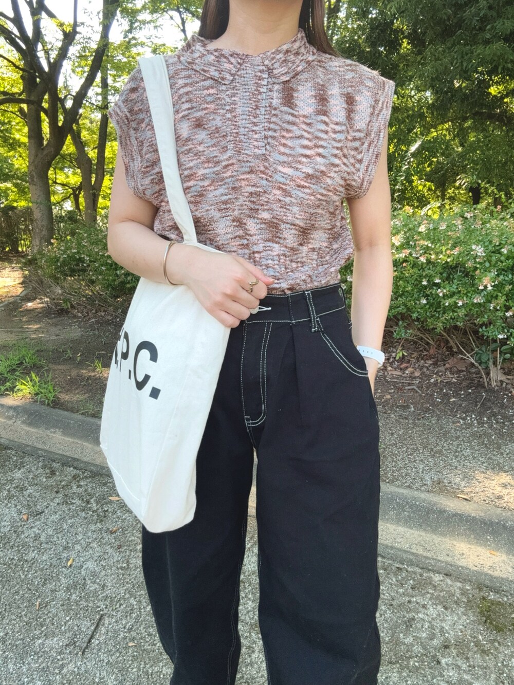 ピンク系のニット/セーター、ブラック系のデニムパンツ、ブラック系のサンダルを着用したレディースの夏コーディネートの4枚目の写真
