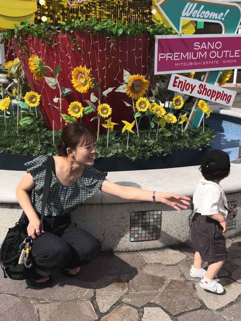 ブラック系のサンダル、グリーン系のトップス、ブラック系のパンツを着用したレディースの夏コーディネートの3枚目の写真