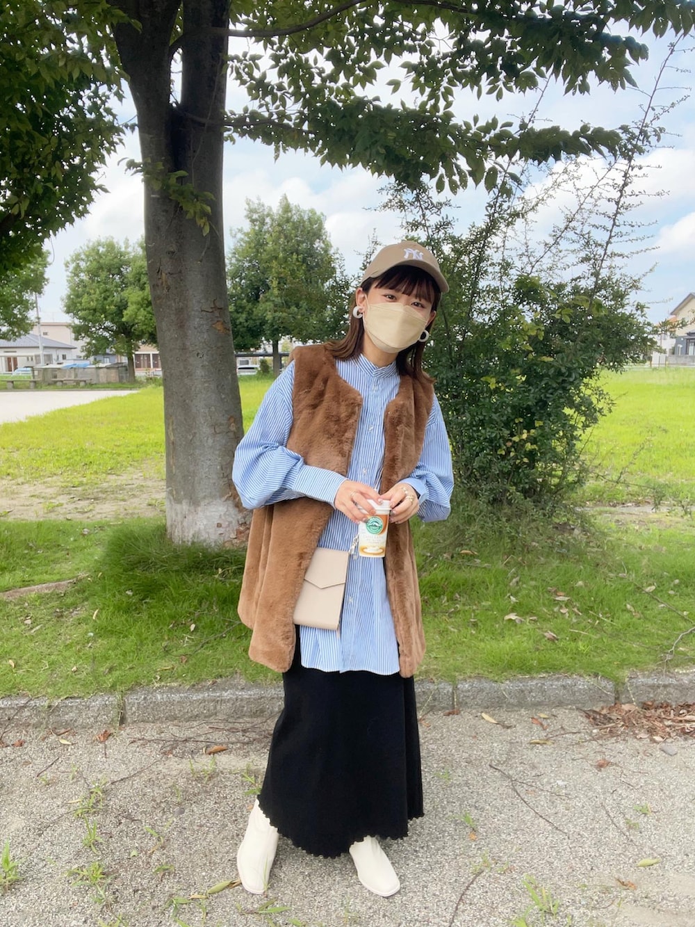 ホワイト系のブーツ、ブルー系のシャツ/ブラウス、ブラウン系のベストを着用したレディースの秋コーディネートの5枚目の写真