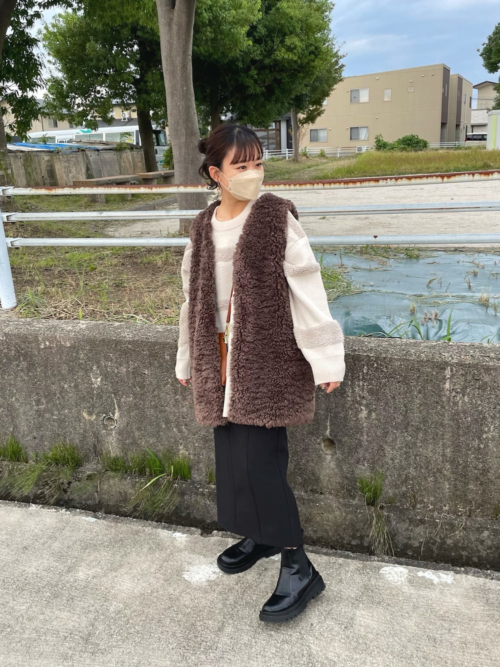 ホワイト系のニット/セーター、ブラウン系のその他アウター、ブラック系のスカートを着用したレディースの秋コーディネートの4枚目の写真