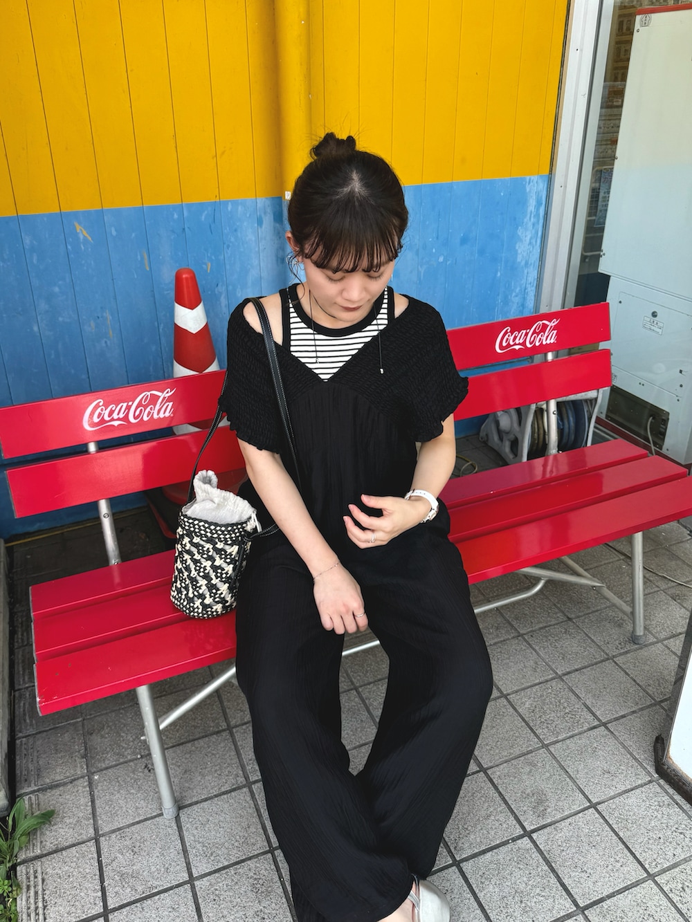 ブラック系のつなぎ/オールインワン、ホワイト系のタンクトップ、ブラック系のショルダーバッグを着用したレディースの夏コーディネートの2枚目の写真