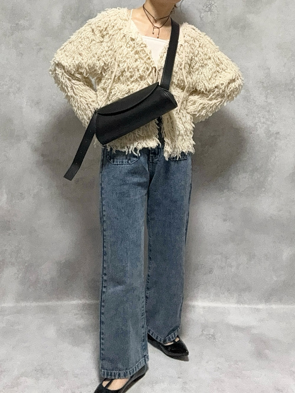 ホワイト系のカーディガン/ボレロ、ホワイト系のキャミソール、ブラック系のショルダーバッグを着用したレディースの秋コーディネートの2枚目の写真