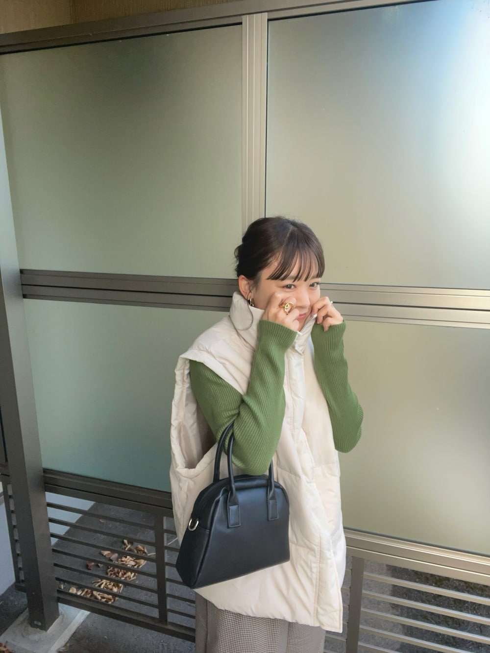 ベージュ系のその他パンツ、ホワイト系のダウンベスト、グリーン系のニット/セーターを着用したレディースの秋コーディネートの5枚目の写真