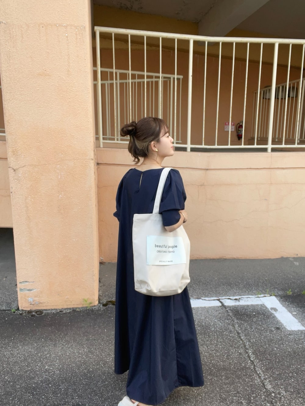 ブルー系のワンピース、ホワイト系のトートバッグ、ホワイト系のサンダルを着用したレディースの夏コーディネートの2枚目の写真