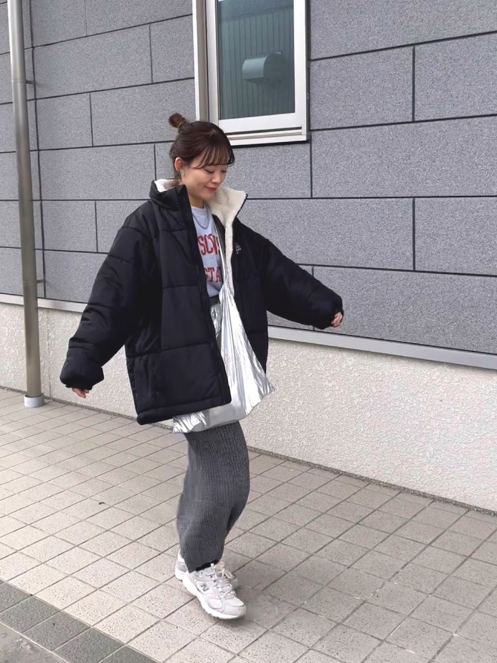 ブラック系のブルゾン、グレー系のTシャツ/カットソー、グレー系のスカートを着用したレディースの冬コーディネートの2枚目の写真