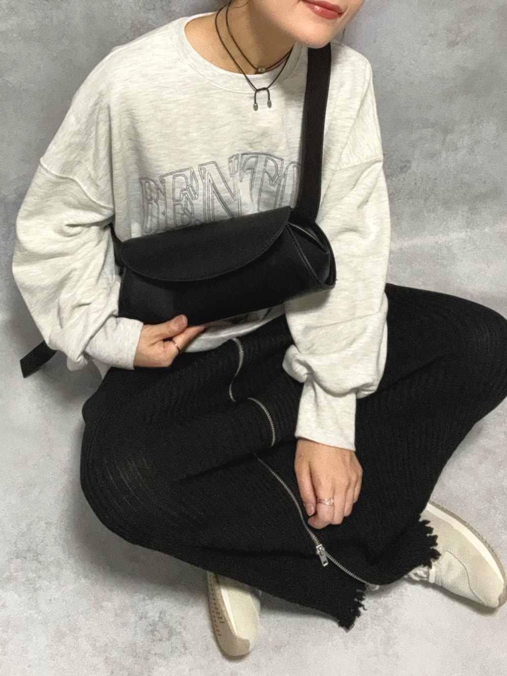 グレー系のスウェット、ブラック系のショルダーバッグ、ブラック系のスカートを着用したレディースの秋コーディネートの5枚目の写真