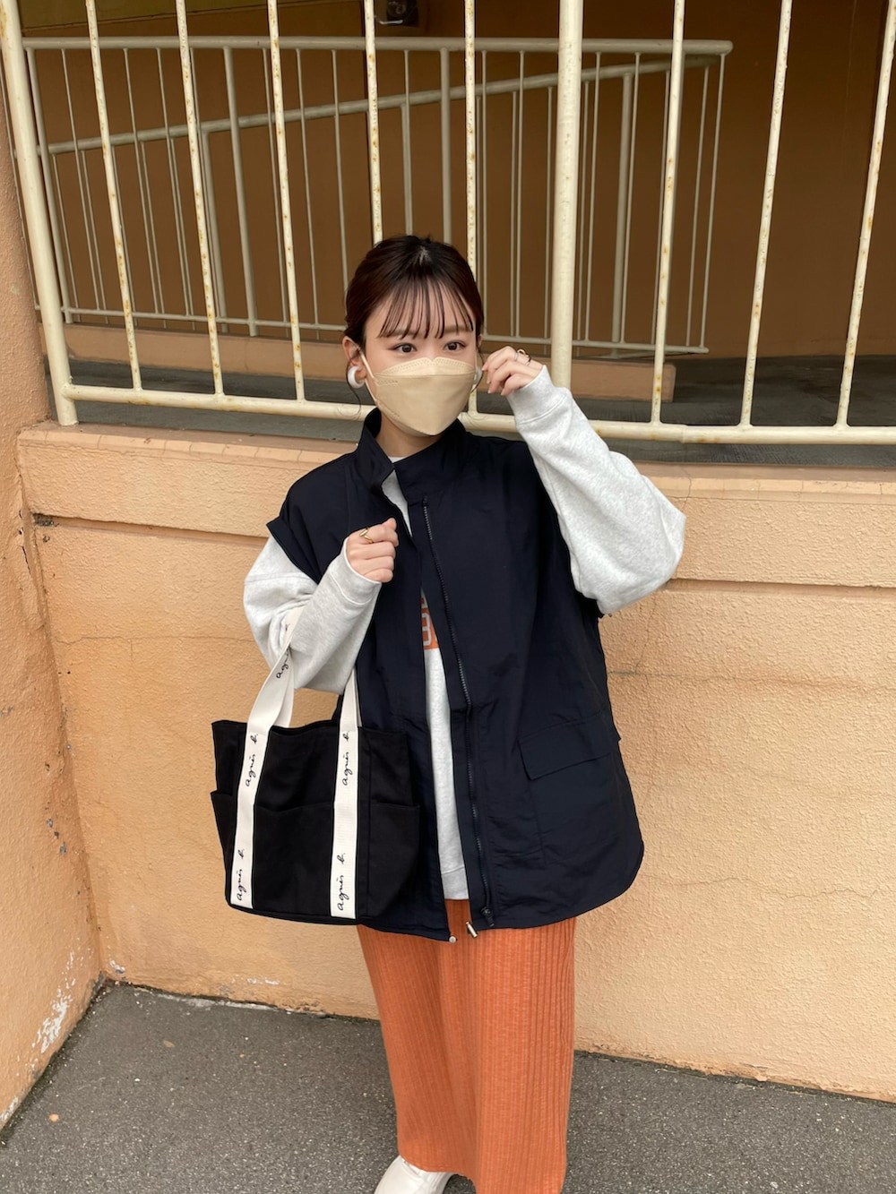 オレンジ系のスカート、ブラック系のマウンテンパーカー、グレー系のスウェットを着用したレディースの冬コーディネートの3枚目の写真