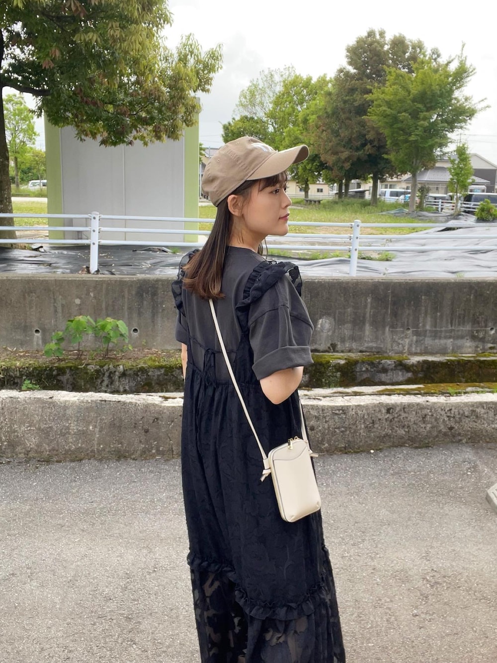 ブラック系のワンピース、ブラック系のTシャツ/カットソー、ブラック系のサンダルを着用したレディースの春コーディネートの4枚目の写真