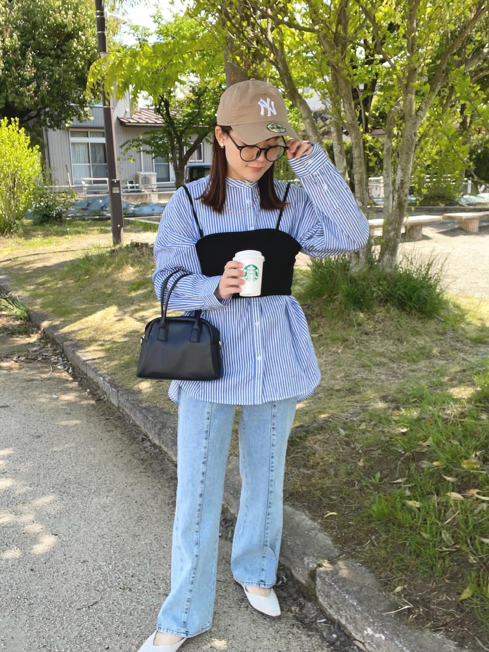 ブルー系のシャツ/ブラウス、ブラック系のその他トップス、ブルー系のデニムパンツを着用したレディースの春コーディネートの5枚目の写真