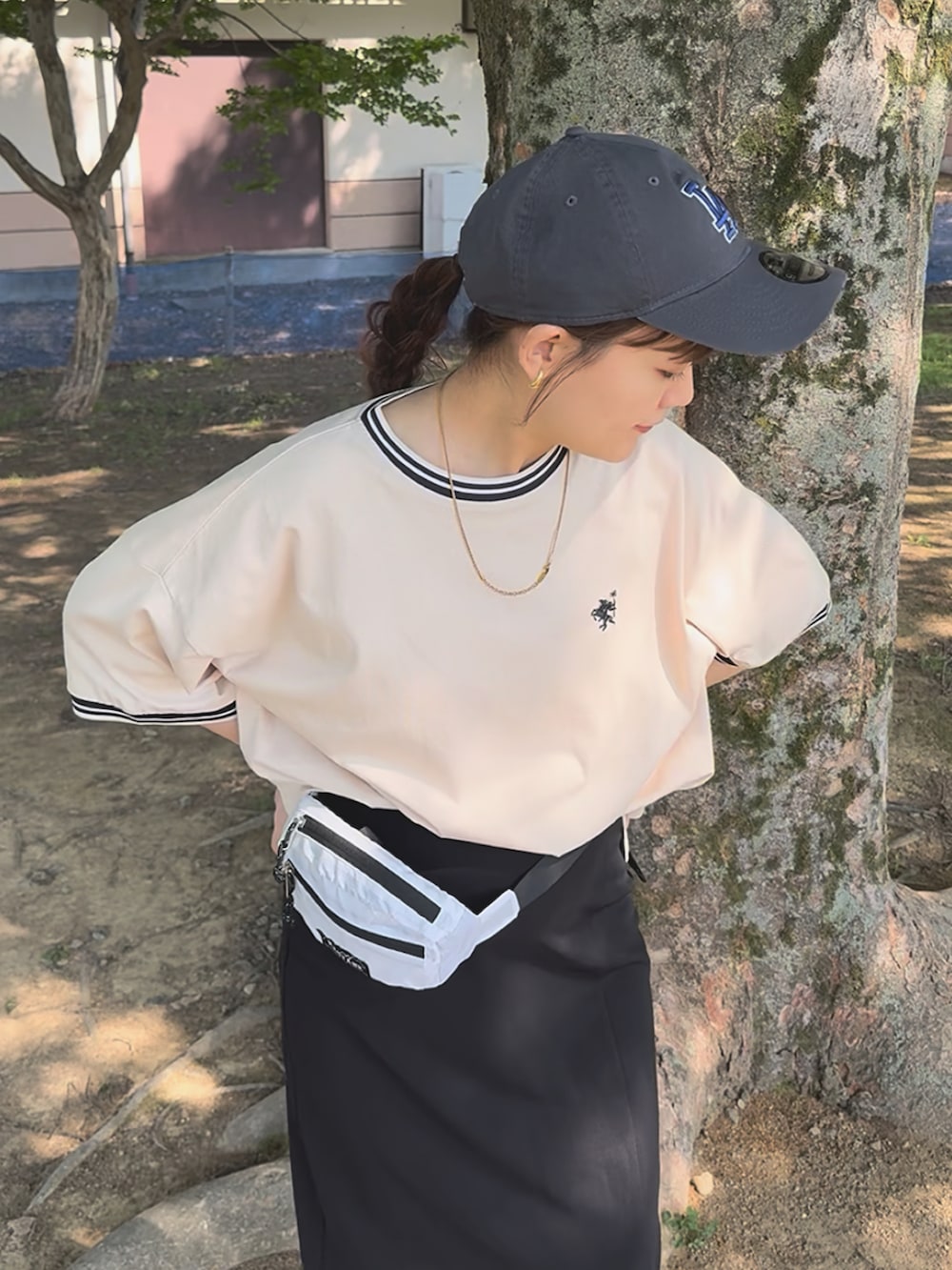 ホワイト系のTシャツ/カットソー、ブラック系のスカート、ブラック系のサンダルを着用したレディースの夏コーディネートの2枚目の写真
