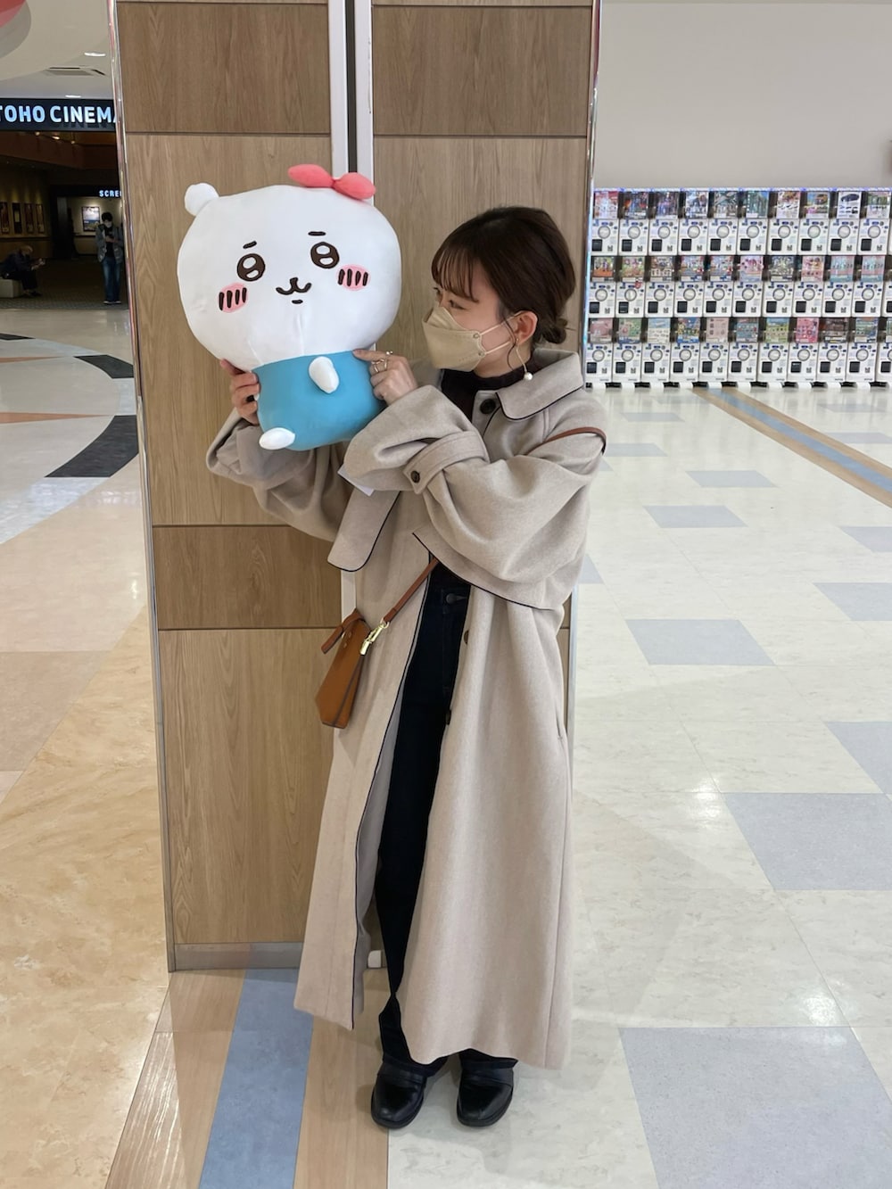 ベージュ系のジャケット/アウター、ブラウン系のニット/セーター、ブルー系のデニムパンツを着用したレディースの秋コーディネートの2枚目の写真