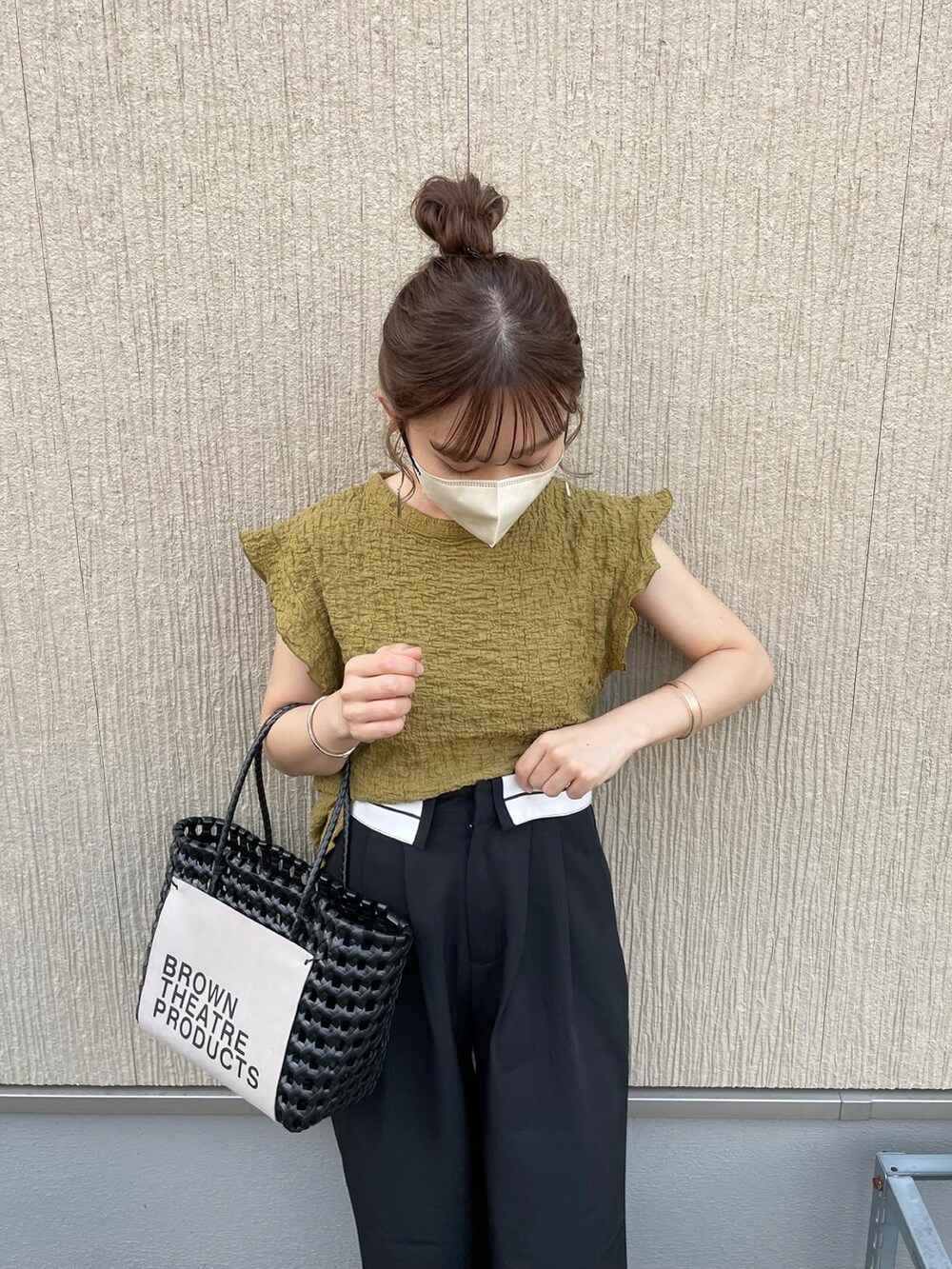 グリーン系のシャツ/ブラウス、ブラック系のパンツ、ブラック系のハンドバッグを着用したレディースの夏コーディネートの2枚目の写真