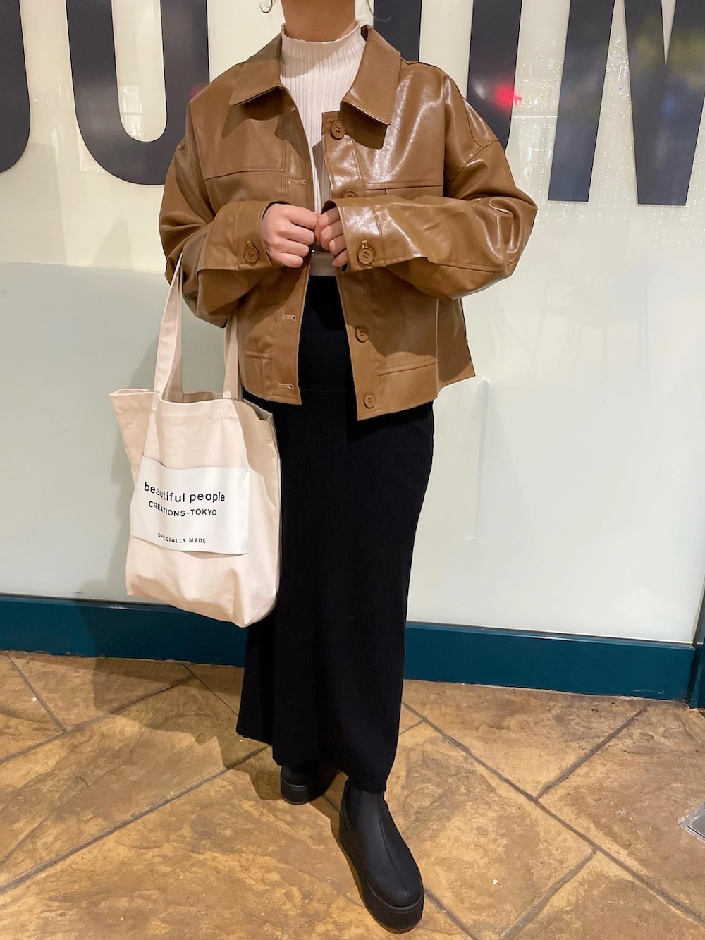 ブラウン系のその他アウター、ホワイト系のニット/セーター、ブラック系のブーツを着用したレディースの秋コーディネートの4枚目の写真