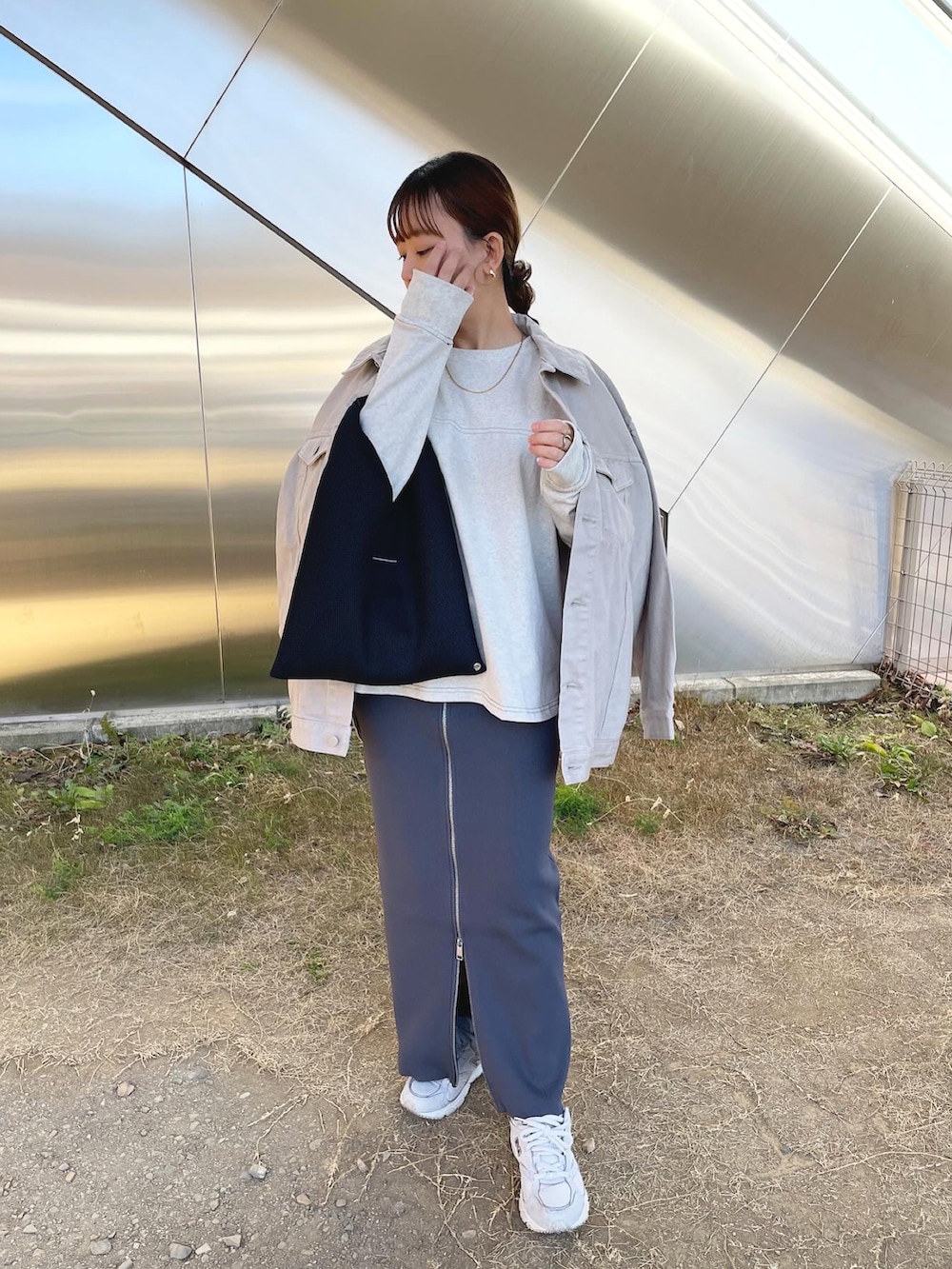 グレー系のデニムジャケット、ベージュ系のTシャツ/カットソー、グレー系のスカートを着用したレディースの春コーディネートの3枚目の写真