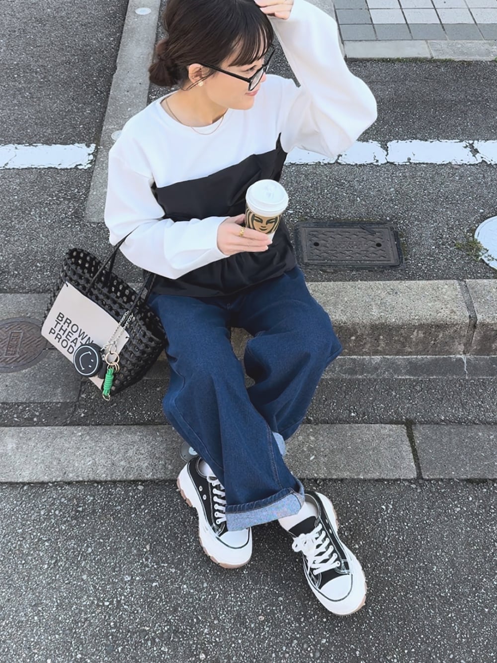 ホワイト系のTシャツ/カットソー、ブラック系のハンドバッグ、ブルー系のパンツを着用したレディースの春コーディネートの2枚目の写真