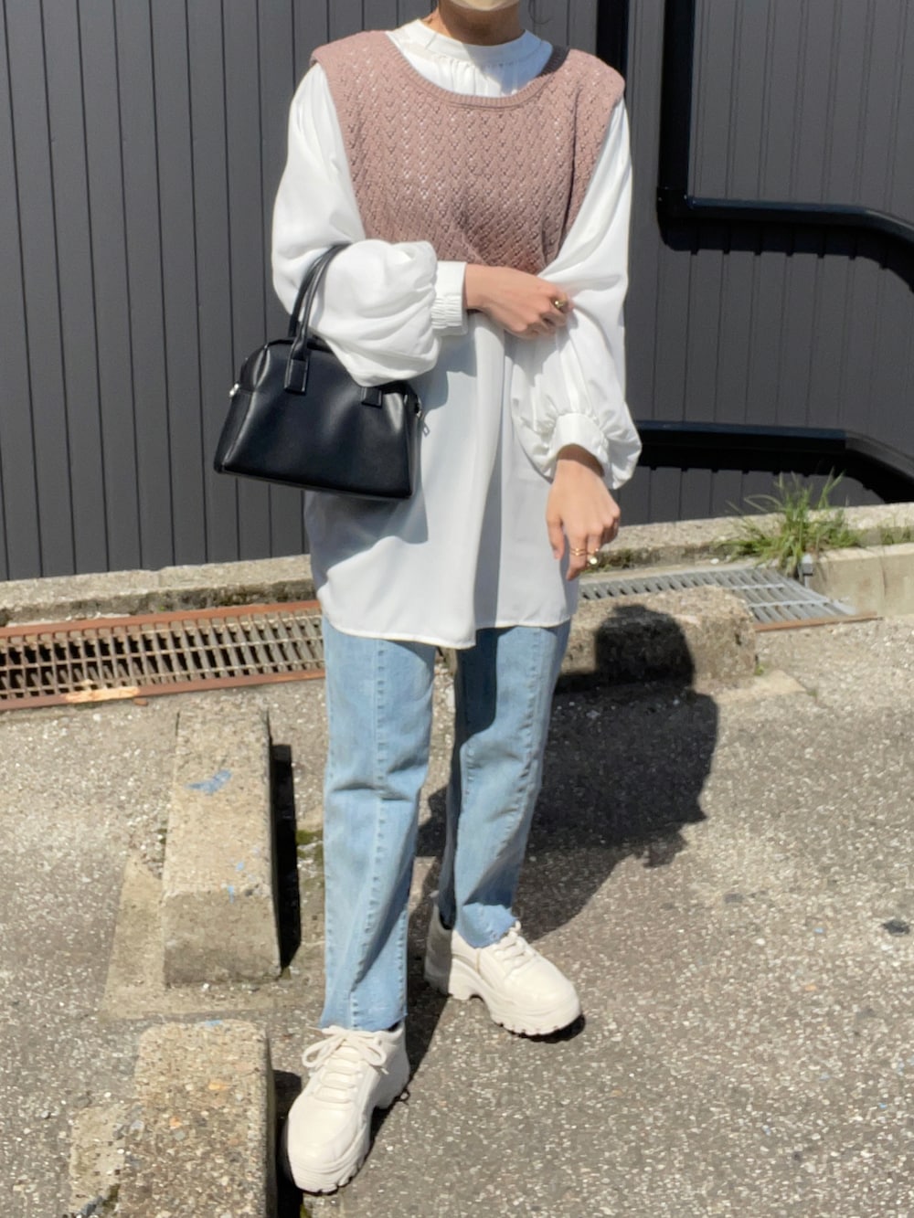 ブラウン系のベスト、ホワイト系のシャツ/ブラウス、ブルー系のデニムパンツを着用したレディースの春コーディネートの4枚目の写真