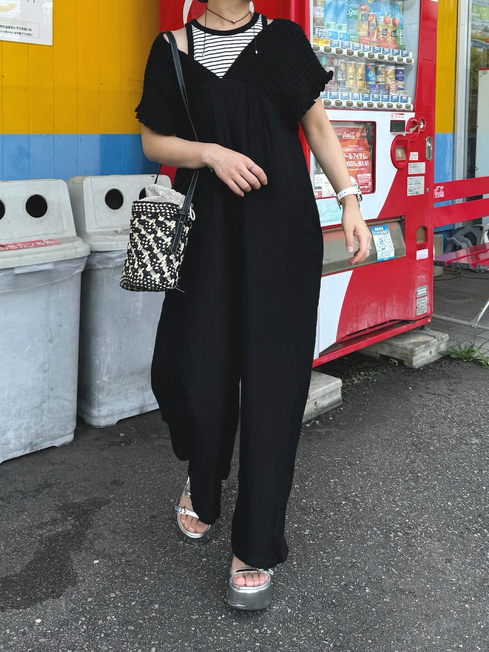 ブラック系のつなぎ/オールインワン、ホワイト系のタンクトップ、ブラック系のショルダーバッグを着用したレディースの夏コーディネートの4枚目の写真