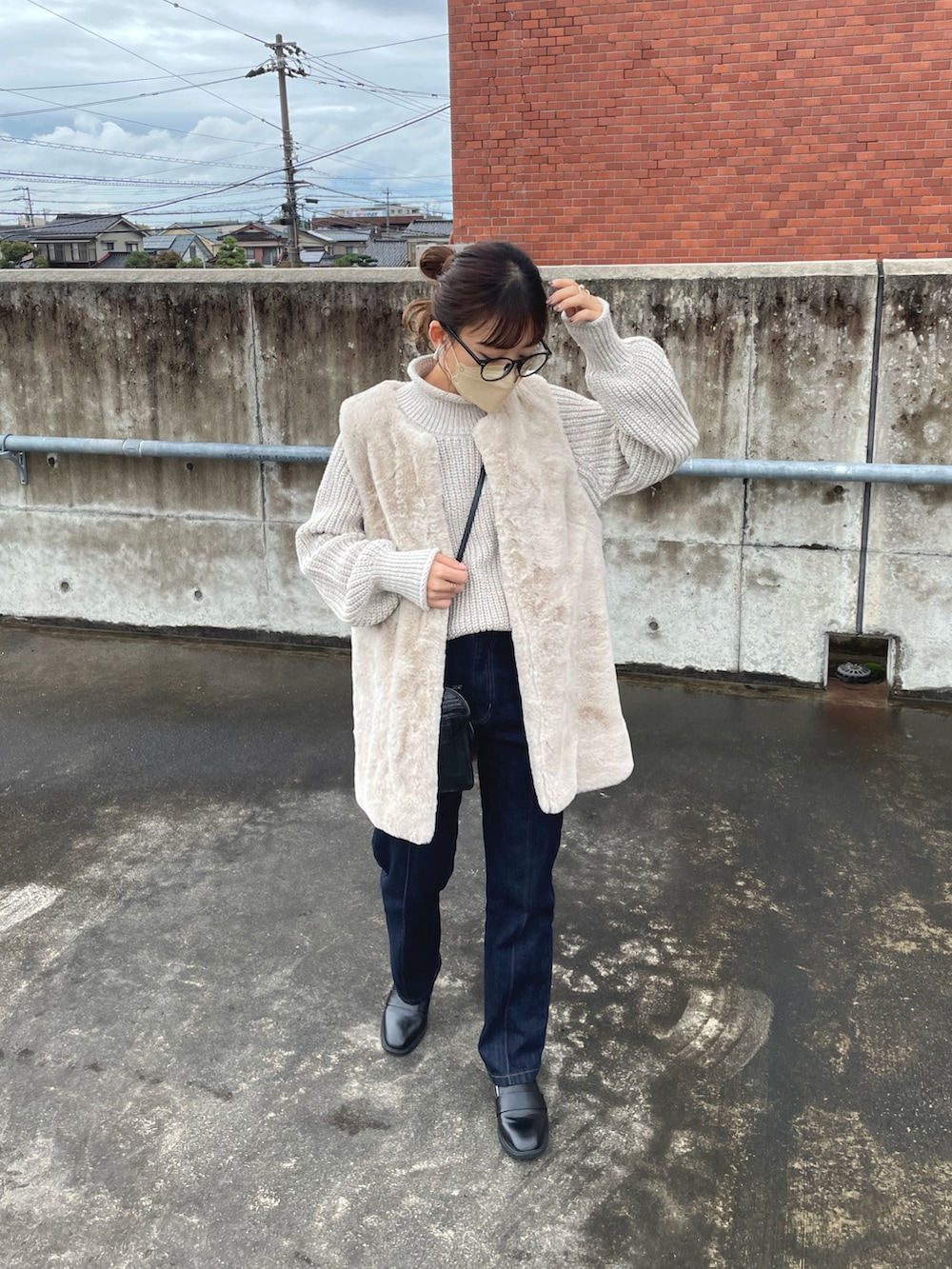 ベージュ系のニット/セーター、グレー系のベスト、ブラック系のデニムパンツを着用したレディースの秋コーディネートの2枚目の写真