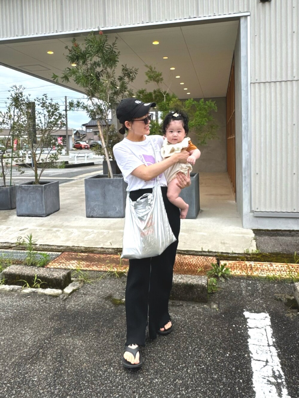 ホワイト系のTシャツ/カットソー、ブラック系のスカート、シルバー系のトートバッグを着用したレディースの夏コーディネートの2枚目の写真