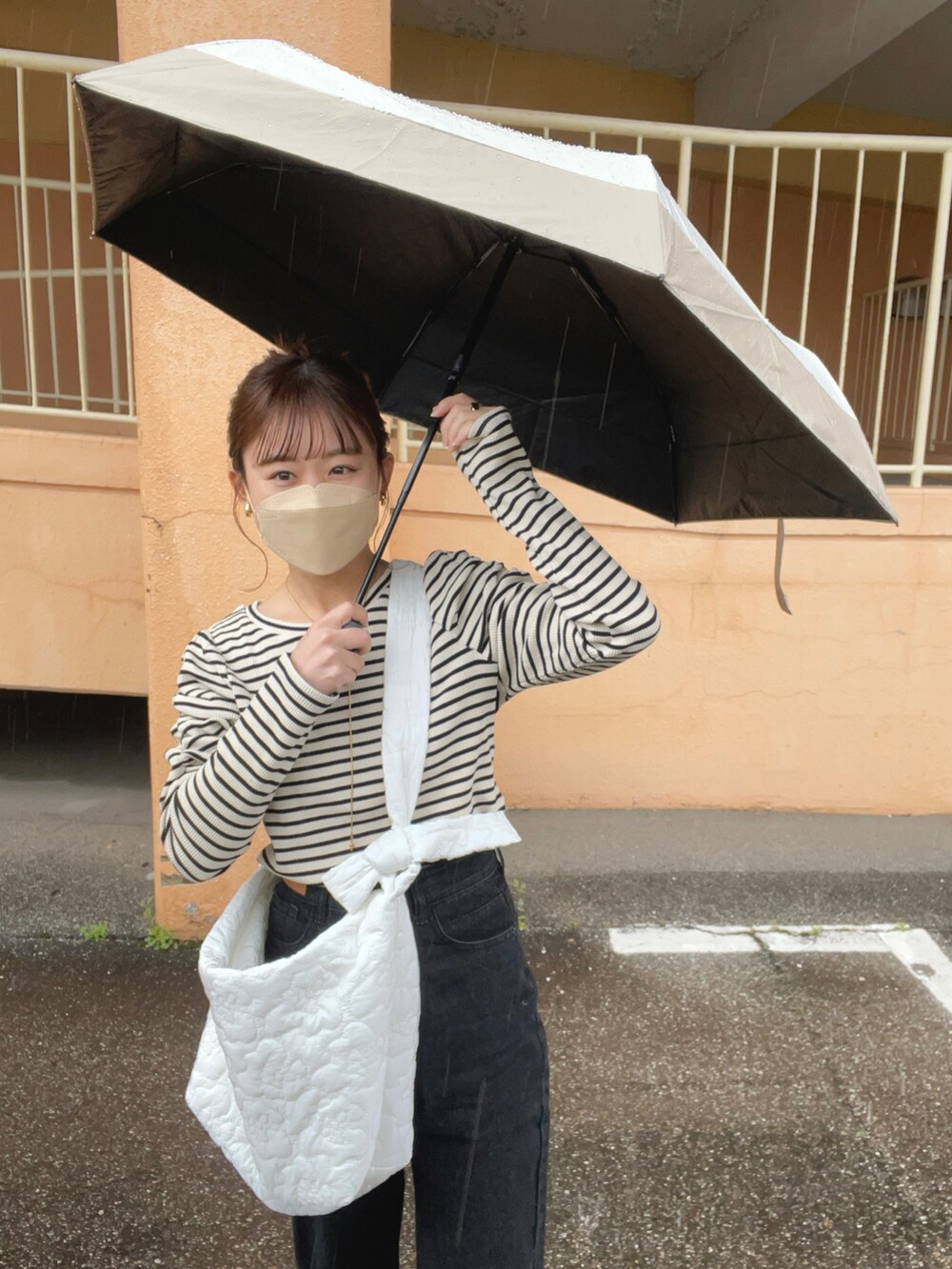 ブラック系のTシャツ/カットソー、ブラック系のデニムパンツ、ホワイト系のショルダーバッグを着用したレディースの春コーディネートの3枚目の写真