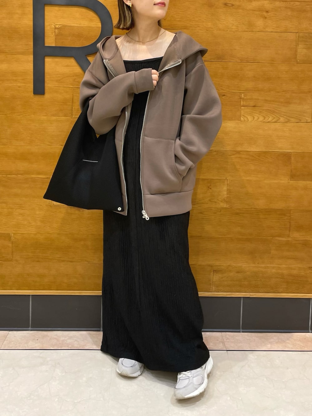 ブラウン系のパーカー、ブラック系のワンピース/ドレス、ブラック系のトートバッグを着用したレディースの秋コーディネートの2枚目の写真
