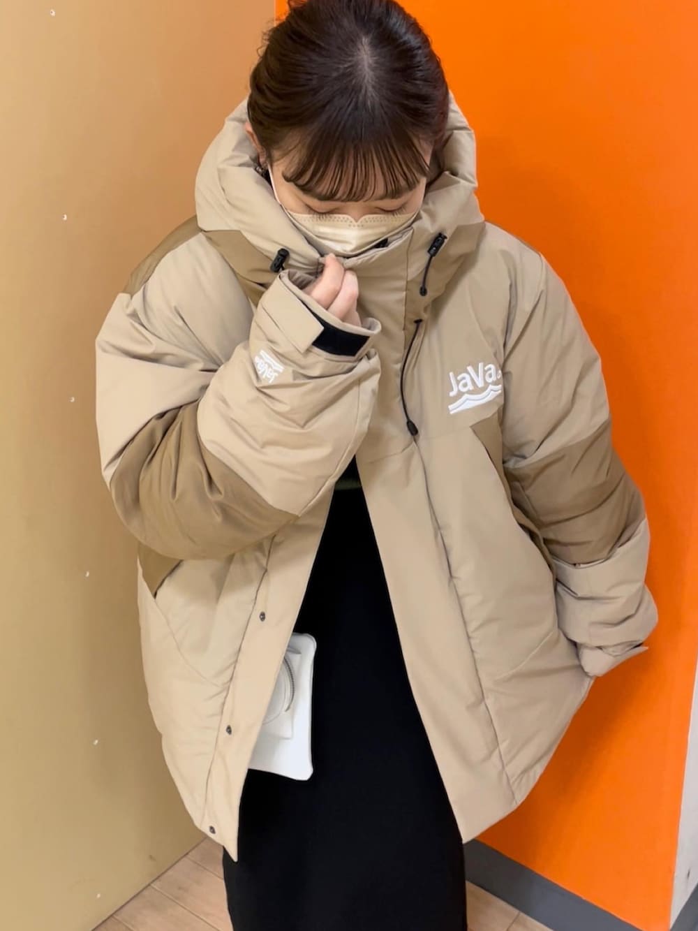 ベージュ系のダウンジャケット/コート、グリーン系のニット/セーター、ブラック系のスカートを着用したレディースの冬コーディネートの3枚目の写真