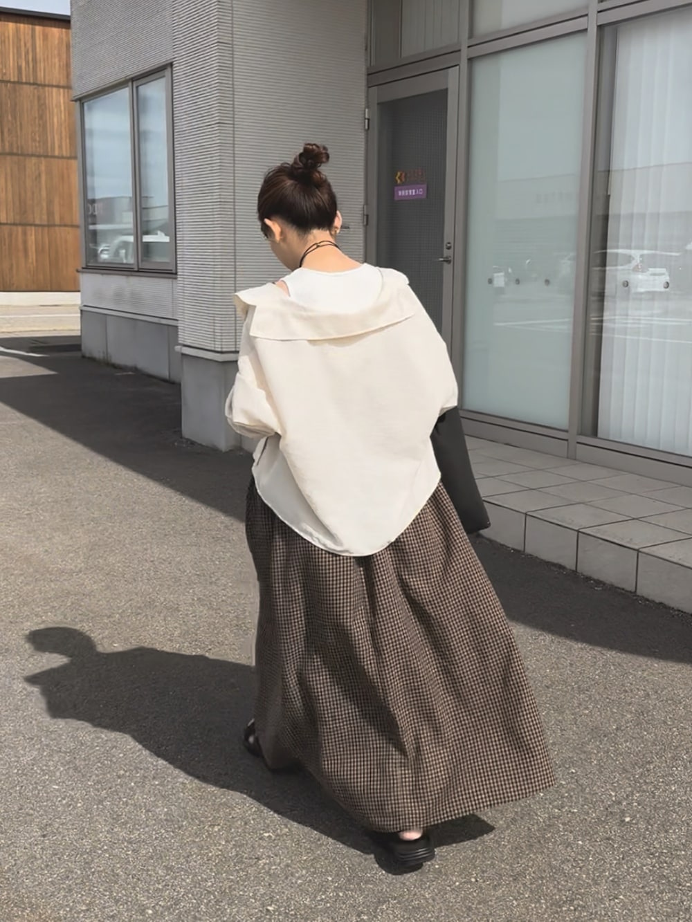 ブラウン系のワンピース、ブラック系のサンダル、ブラック系のトートバッグを着用したレディースの夏コーディネートの3枚目の写真
