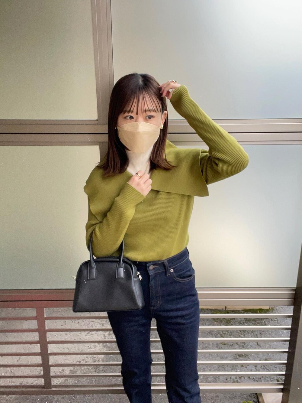 グリーン系のニット/セーター、ホワイト系のニット/セーター、ブルー系のデニムパンツを着用したレディースの冬コーディネートの2枚目の写真