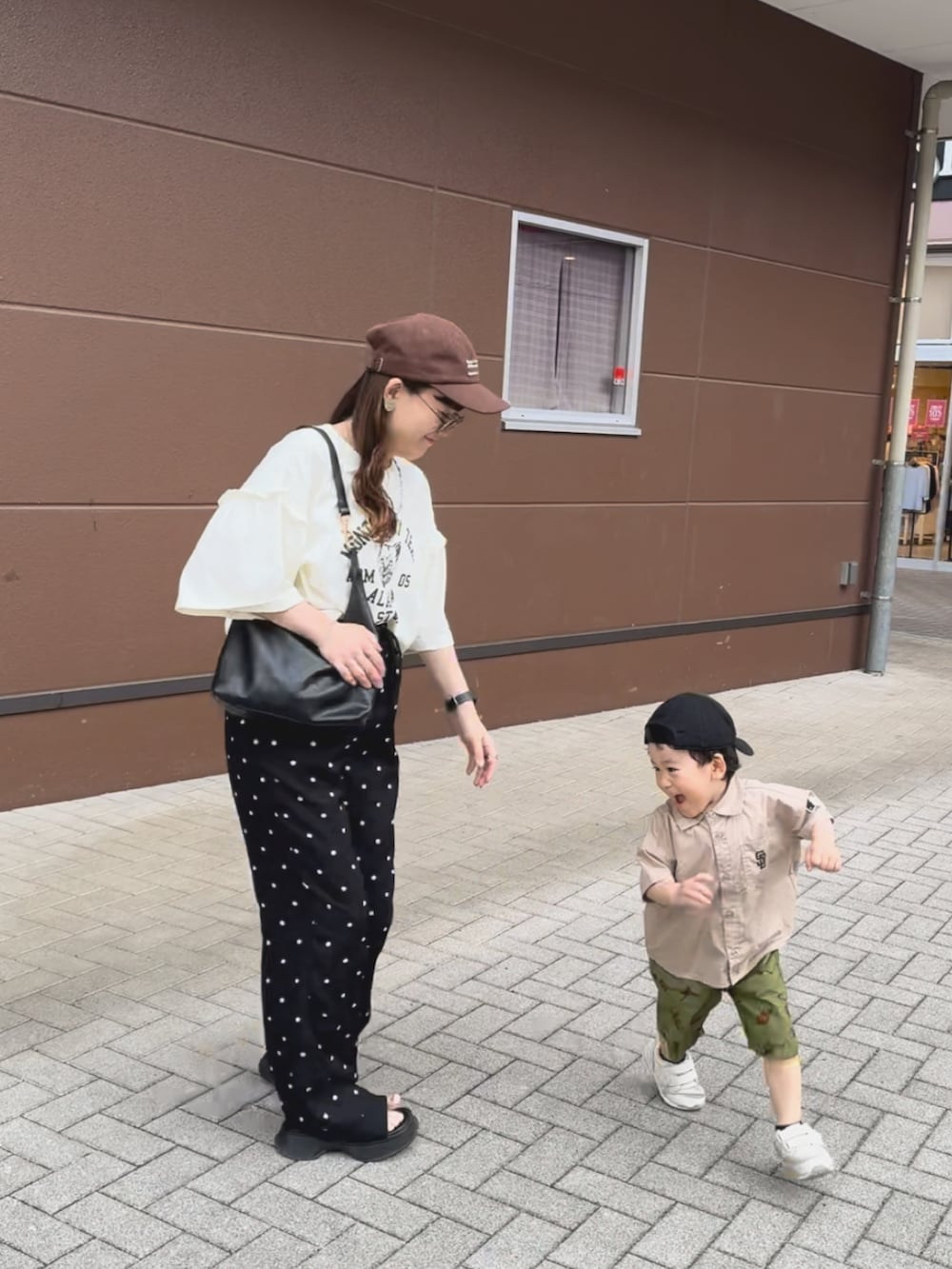 ホワイト系のTシャツ/カットソー、ブラック系のパンツ、ブラック系のバッグを着用したレディースの夏コーディネートの4枚目の写真