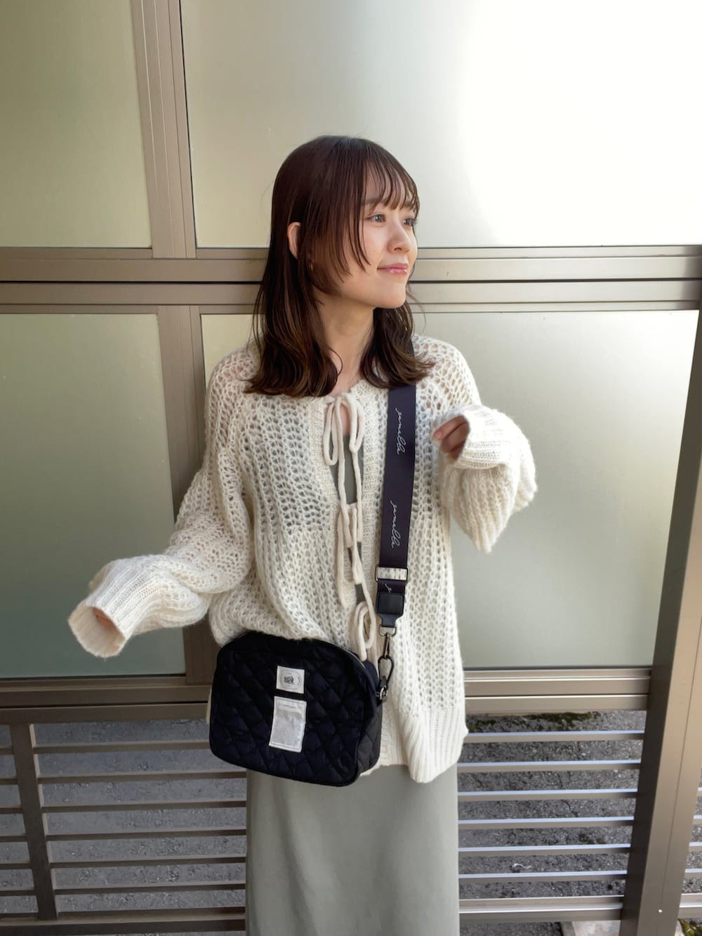 ホワイト系のカーディガン/ボレロ、ブラック系のショルダーバッグ、グリーン系のワンピース/ドレスを着用したレディースの春コーディネートの2枚目の写真