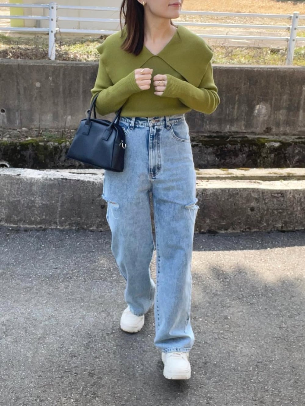 グリーン系のニット/セーター、その他のデニムパンツ、ブラック系のボストンバッグを着用したレディースの春コーディネートの4枚目の写真