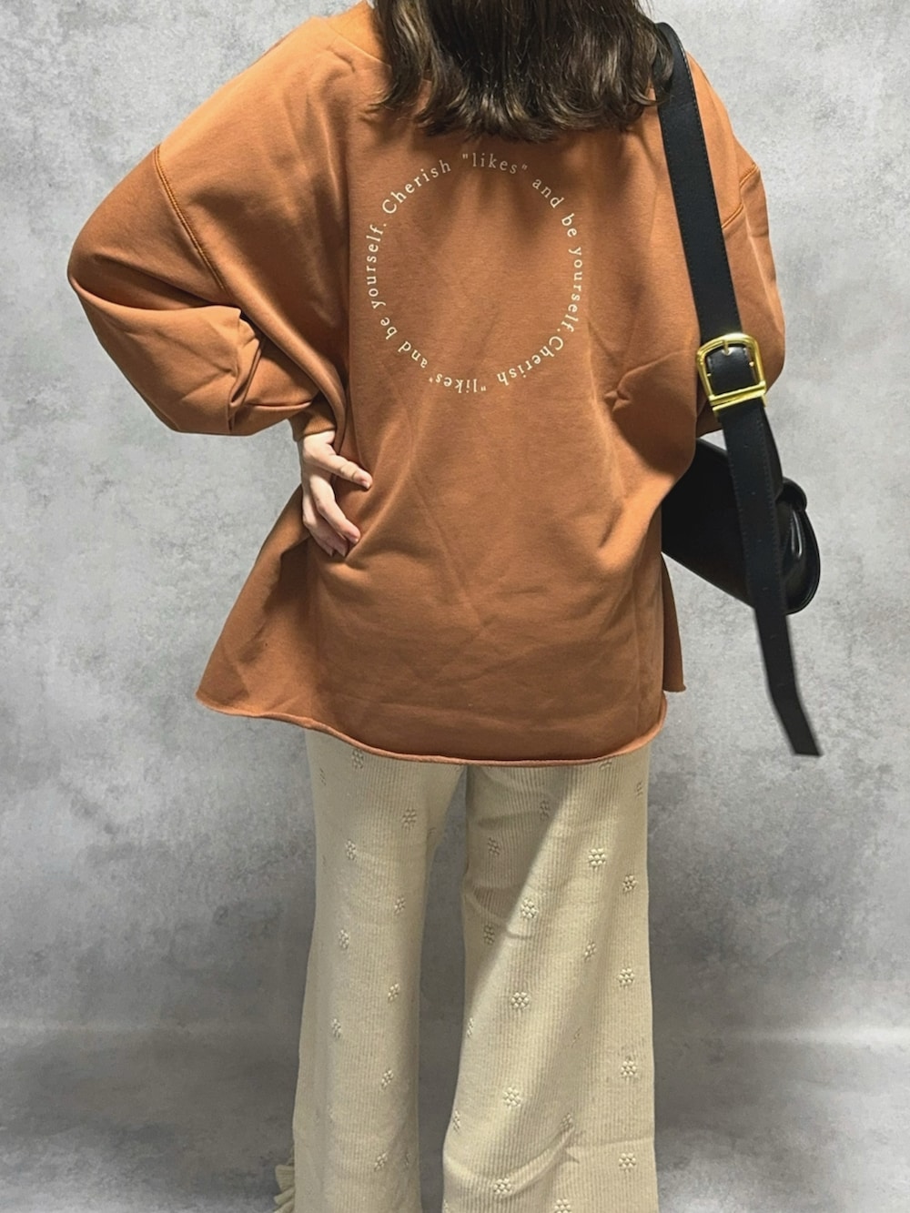 ブラウン系のスウェット、ホワイト系のその他パンツ、ブラック系のショルダーバッグを着用したレディースの秋コーディネートの4枚目の写真