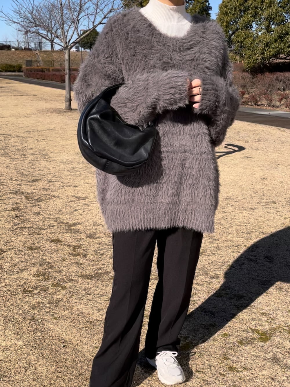 ベージュ系のカーディガン/ボレロ、ブラック系のスラックス、ホワイト系のスニーカーを着用したレディースの冬コーディネートの4枚目の写真