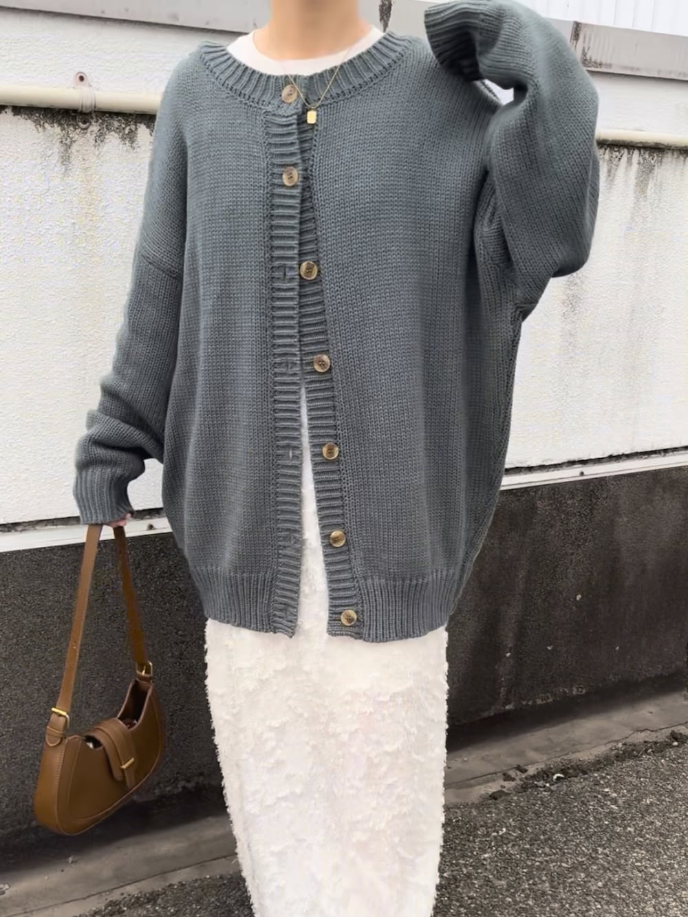 グリーン系のカーディガン/ボレロ、ベージュ系のスニーカー、ホワイト系のワンピース/ドレスを着用したレディースの春コーディネートの2枚目の写真