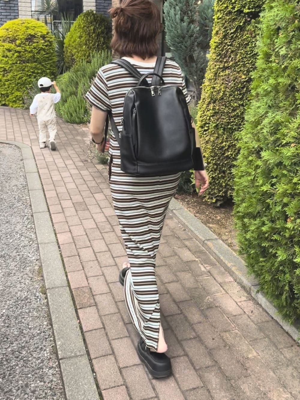 ブラウン系のワンピース、ブラック系のバックパック/リュックを着用したレディースの夏コーディネートの2枚目の写真