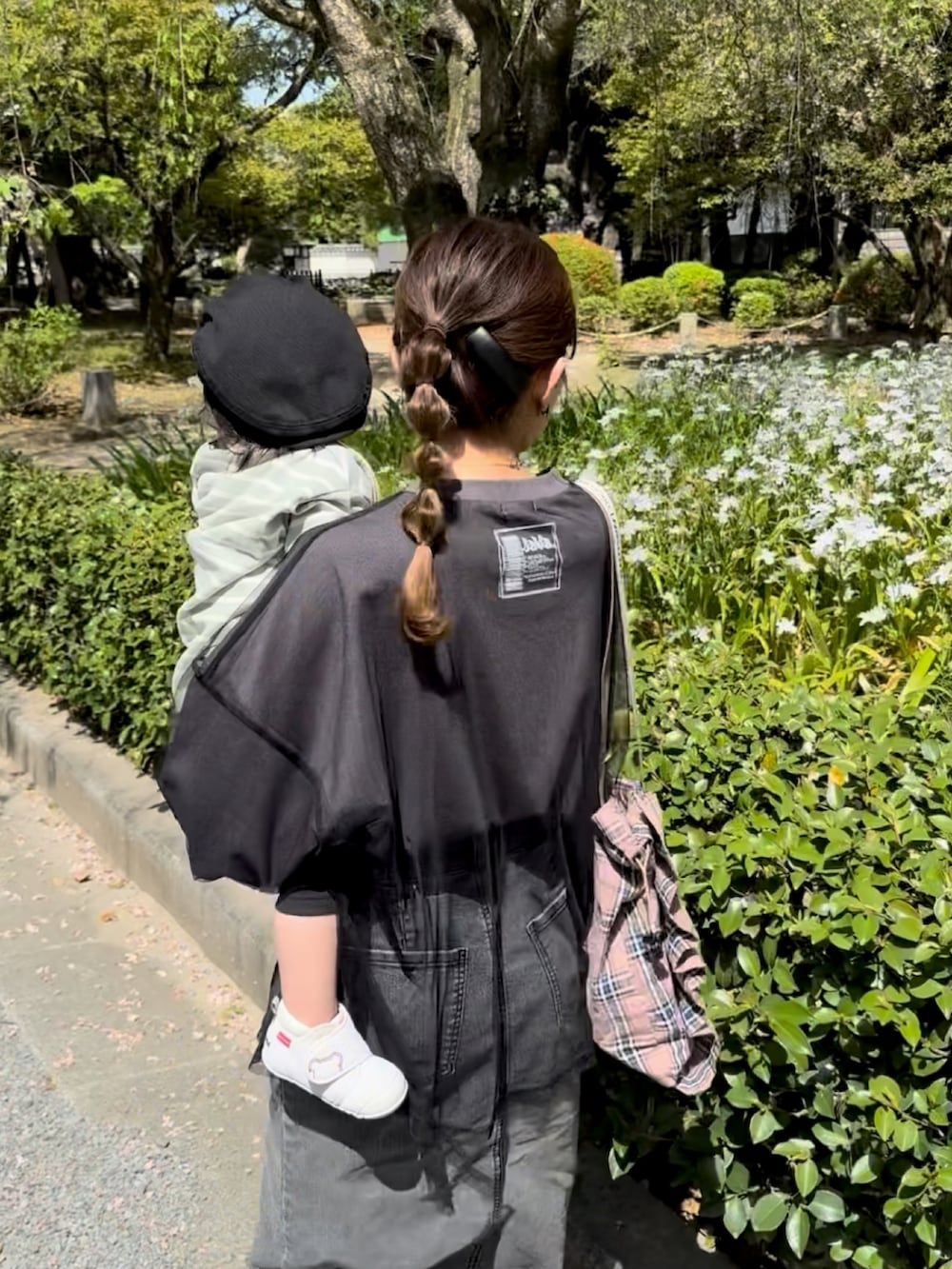 グレー系のTシャツ/カットソー、ピンク系のトートバッグ、ブラック系のデニムスカートを着用したレディースの春コーディネートの3枚目の写真