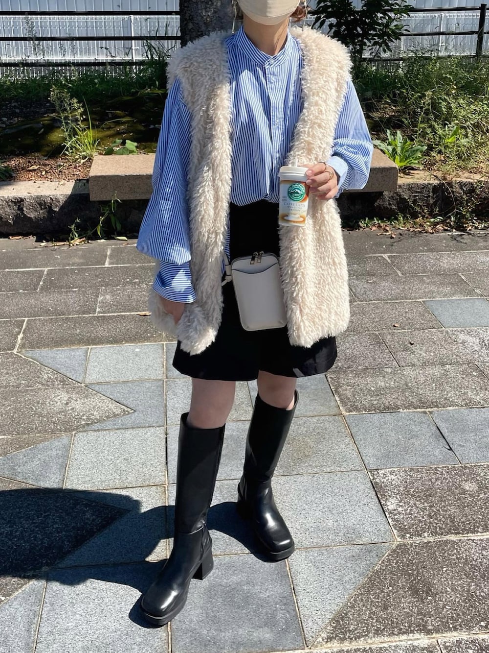 ブルー系のシャツ/ブラウス、ホワイト系のベスト、ブラック系のスラックスを着用したレディースの秋コーディネートの4枚目の写真