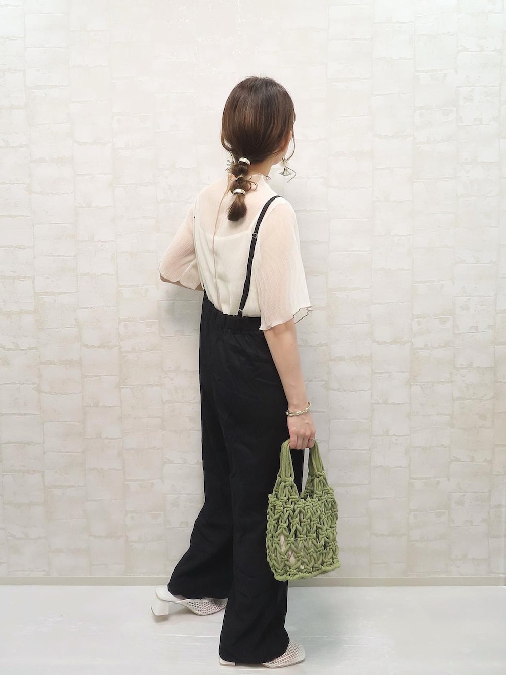 ホワイト系のTシャツ/カットソー、ブラック系のサロペット/オーバーオール、グリーン系のハンドバッグを着用したレディースの春コーディネートの3枚目の写真