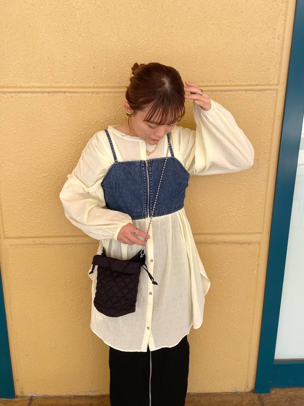 イエロー系のシャツ/ブラウス、ブルー系のトップス、ブラック系のスカートを着用したレディースの春コーディネートの2枚目の写真