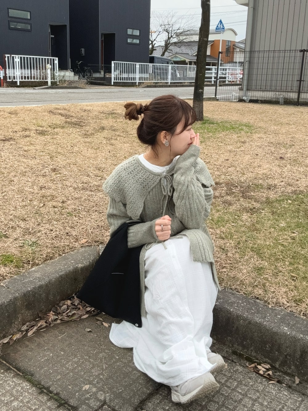 ブラック系のトートバッグ、ホワイト系のスニーカー、グリーン系のカーディガン/ボレロを着用したレディースの冬コーディネートの5枚目の写真