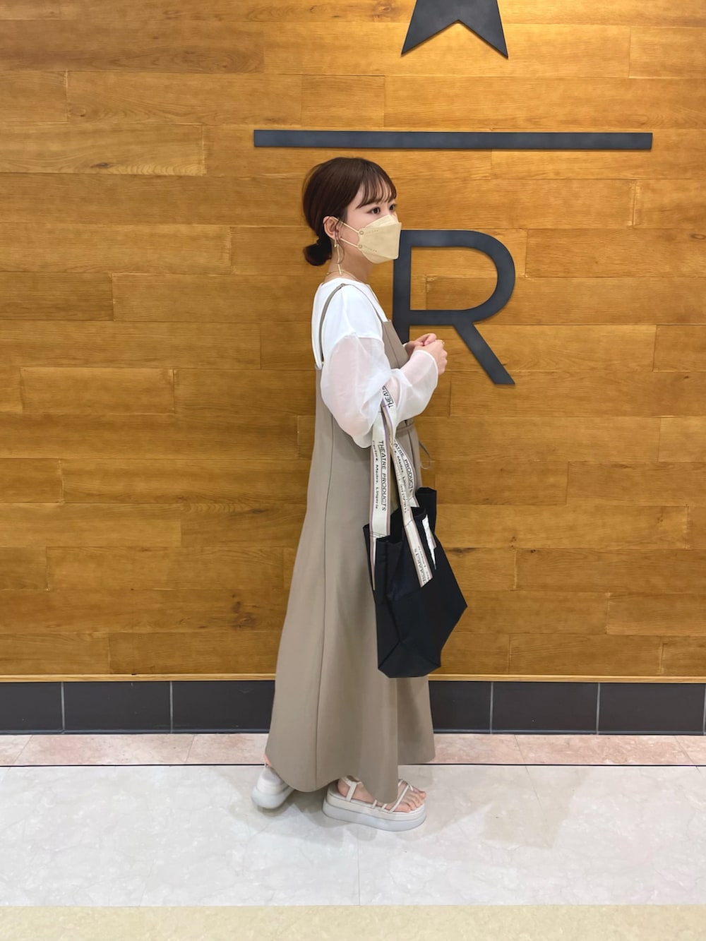 ブラウン系のワンピース、ホワイト系のTシャツ/カットソー、ブラック系のトートバッグを着用したレディースの春コーディネートの3枚目の写真