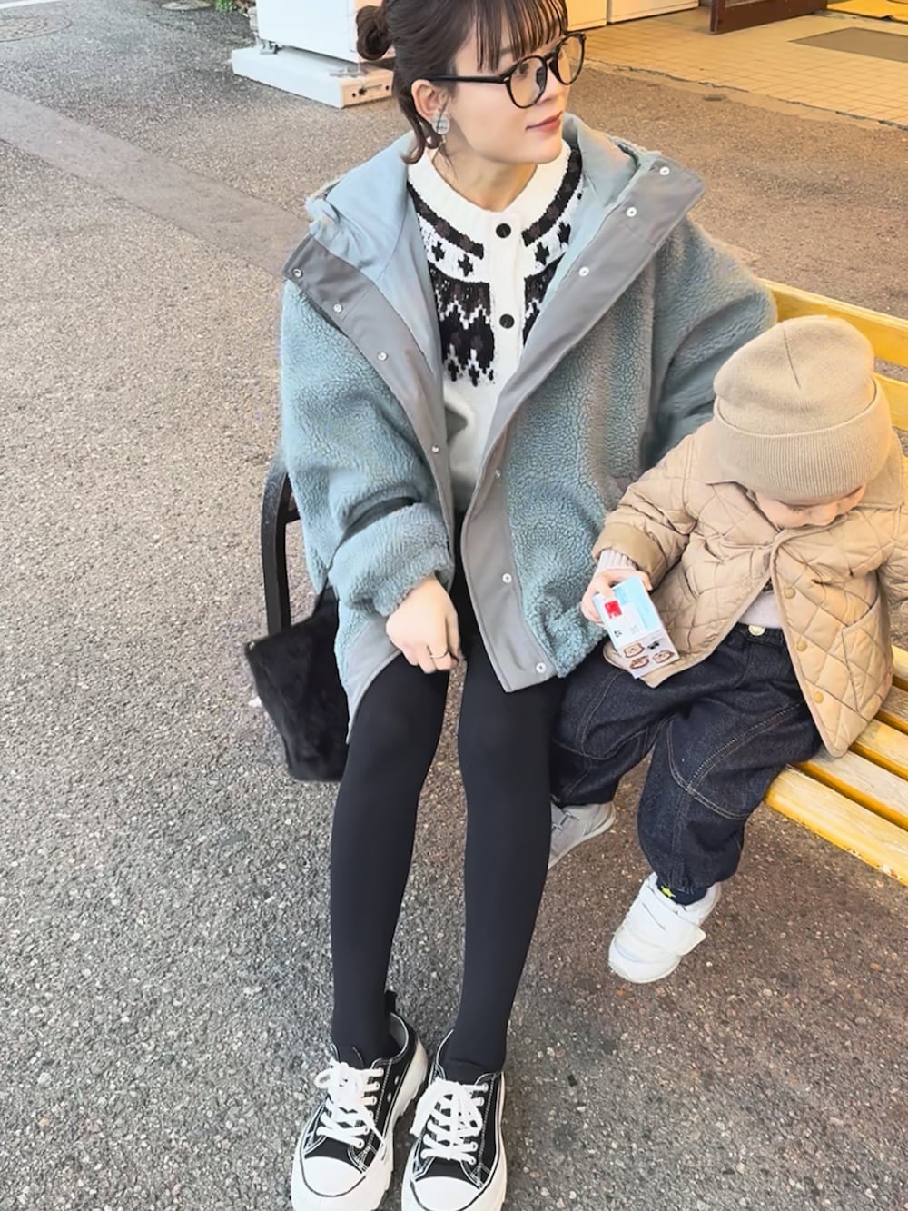 ブルー系のブルゾン、ブラック系のスラックス、ホワイト系のカーディガン/ボレロを着用したレディースの冬コーディネートの3枚目の写真