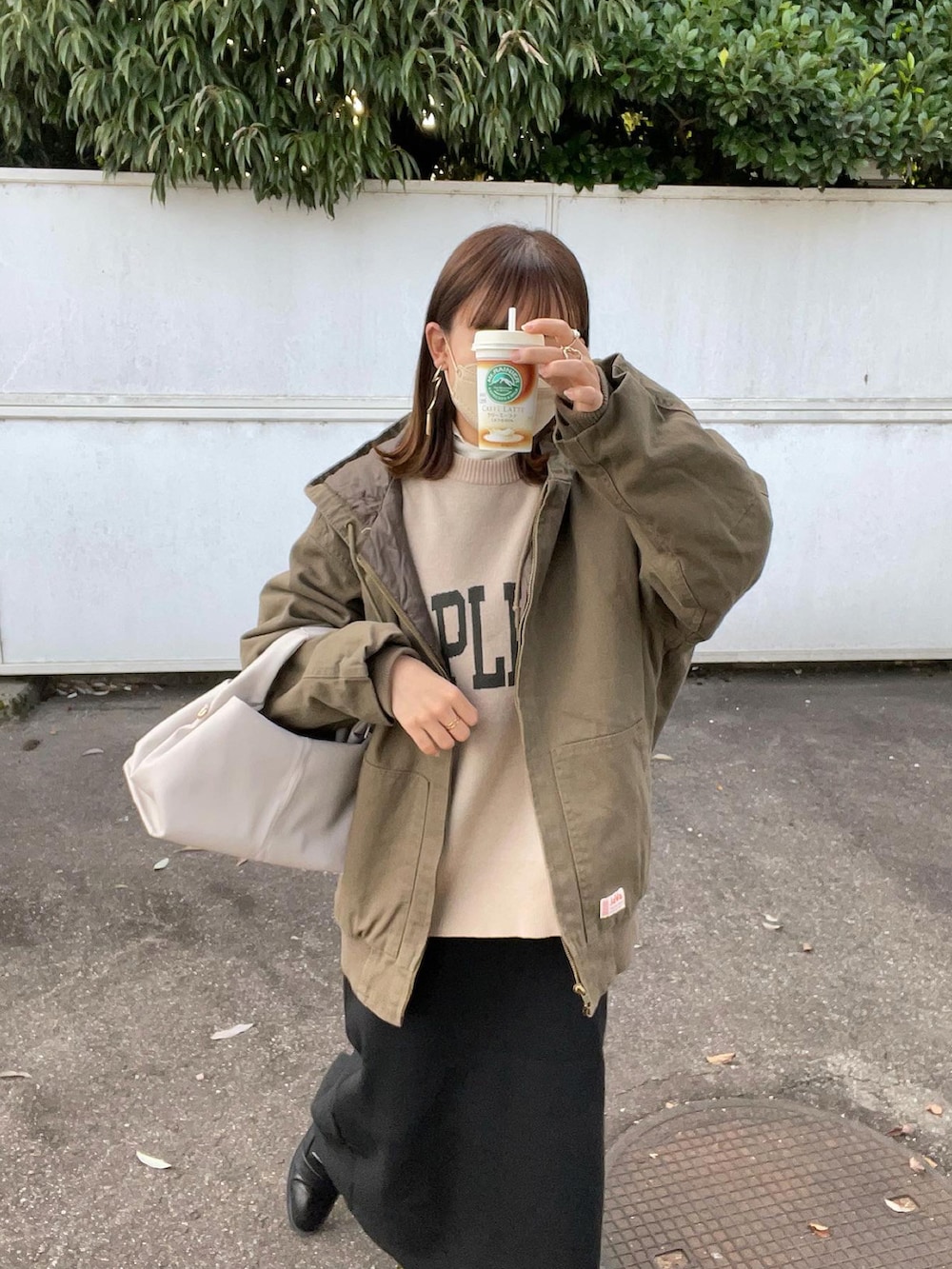 グリーン系のブルゾン、ホワイト系のニット/セーター、ベージュ系のバッグを着用したレディースの秋コーディネートの5枚目の写真