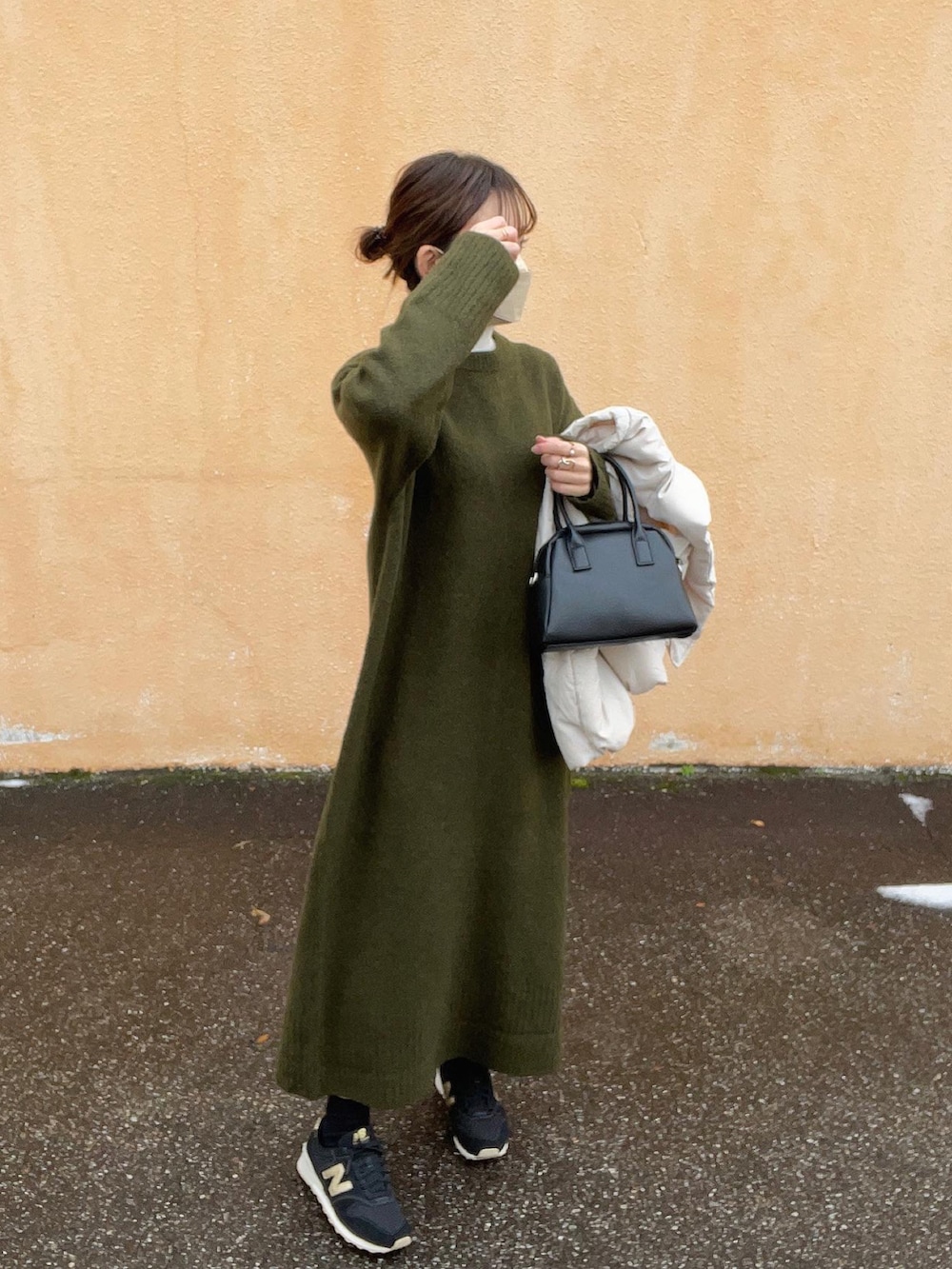 グリーン系のワンピース、ホワイト系のニット/セーター、ホワイト系のダウンベストを着用したレディースの冬コーディネートの3枚目の写真