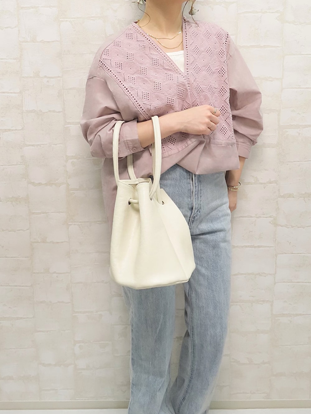 ピンク系のシャツ/ブラウス、ホワイト系のハンドバッグ、ゴールド系のネックレスを着用したレディースの春コーディネートの4枚目の写真